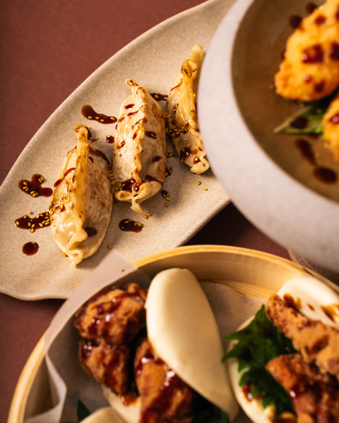 Gyoza e bao al vapore sulla tavola, uno accanto all'altro