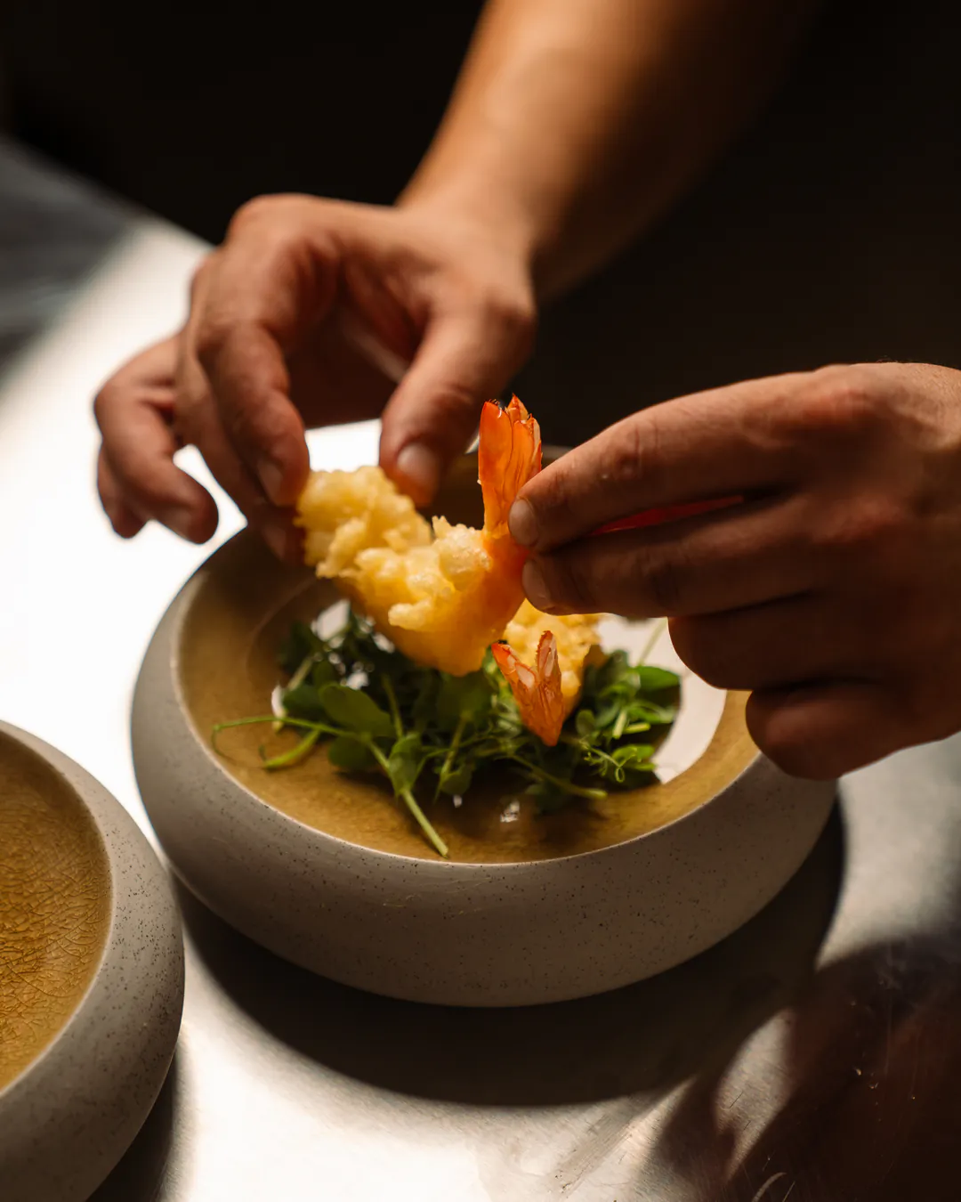 Mani che prendono una mazzancolla in tempura